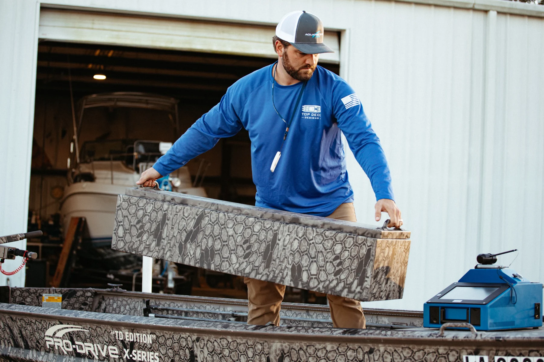 Logan fitting a custom patterned panel into a Pro-Drive hunting boat.