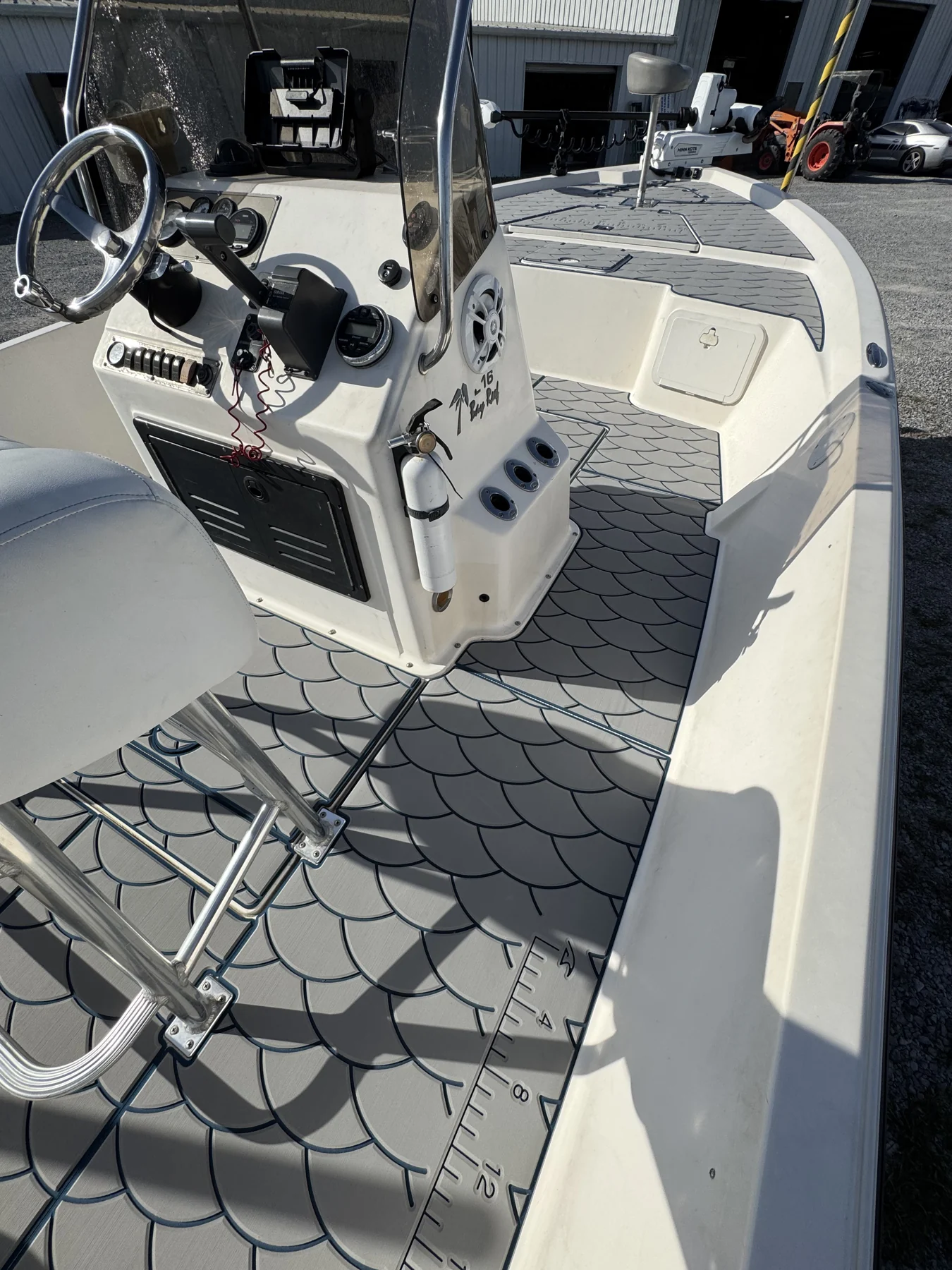 Geometric gray flooring fitted around a fishing boat helm and seating.