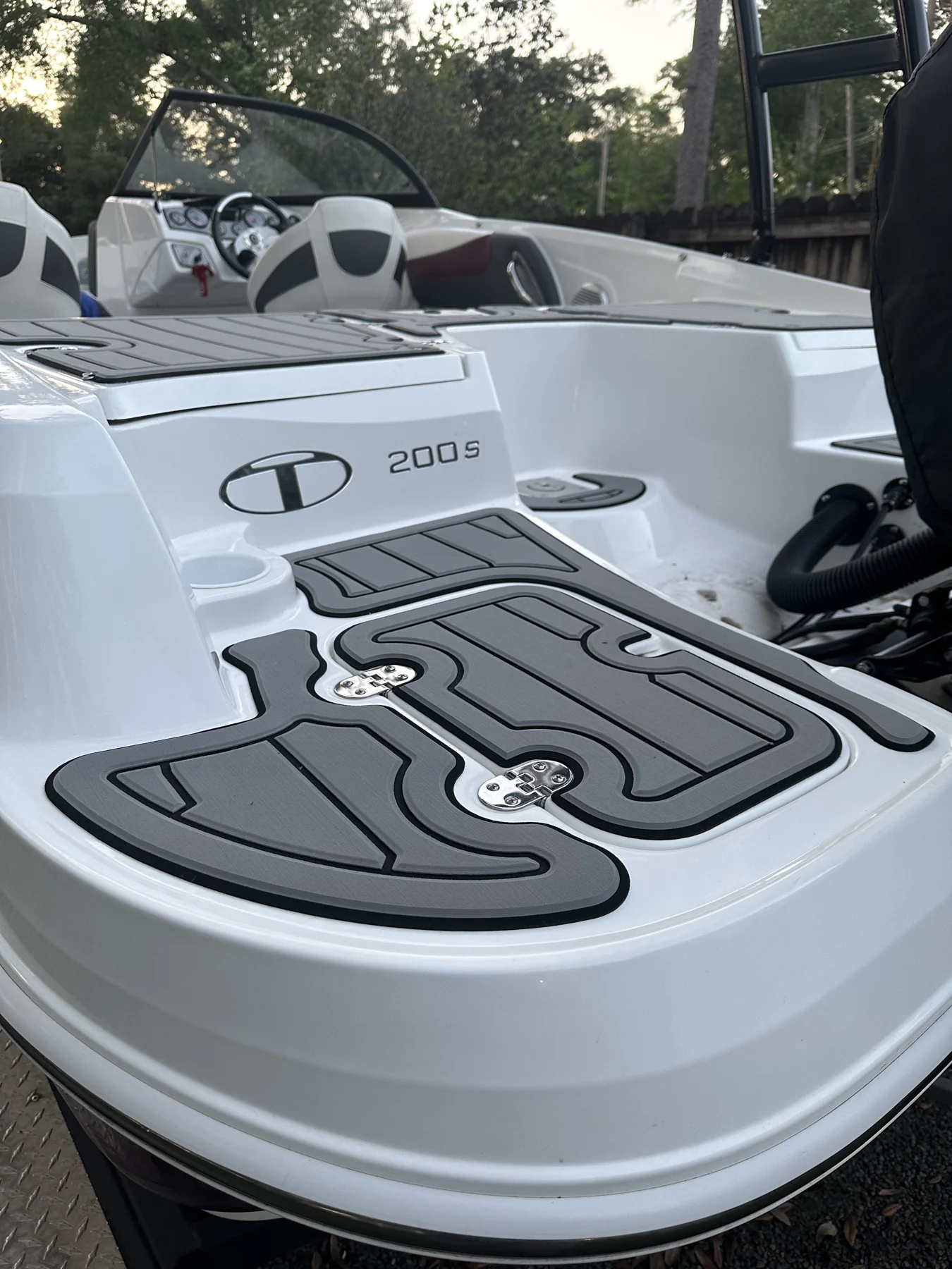 Gray custom hatch panels fitted around the cockpit of a white boat.