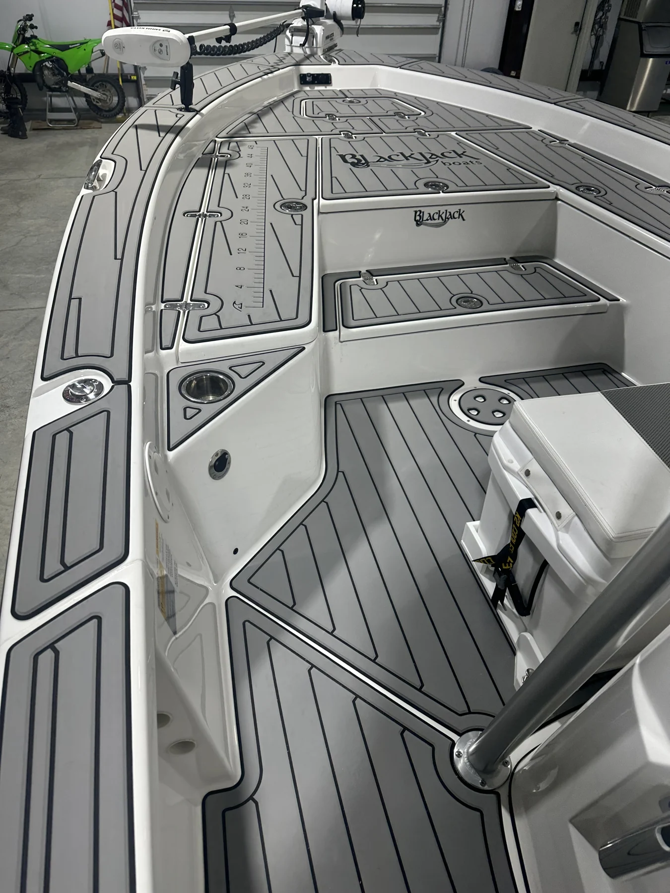 Gray flooring follows the bow hatches and console of a fishing boat.
