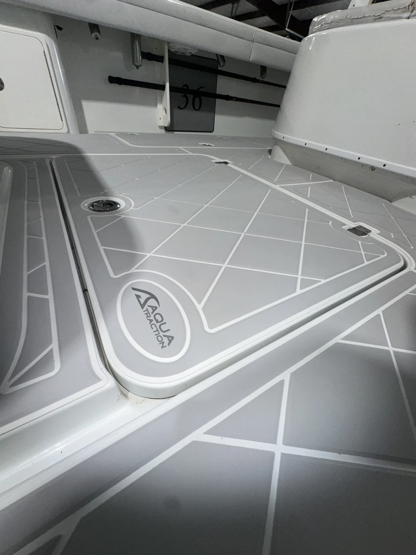 Light gray geometric flooring fitted around a seat base and hatch edges.