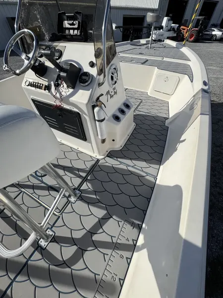 Geometric gray flooring fitted around a fishing boat helm and seating.