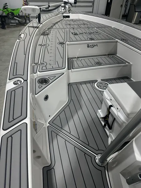 Gray flooring follows the bow hatches and console of a fishing boat.