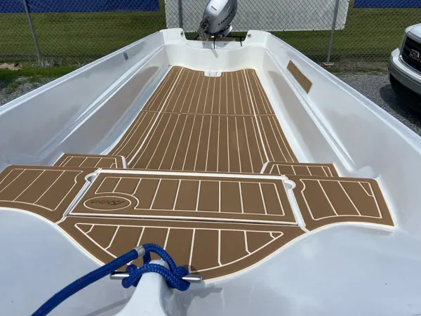 Tan plank-pattern flooring around the bow hatches of a white boat.